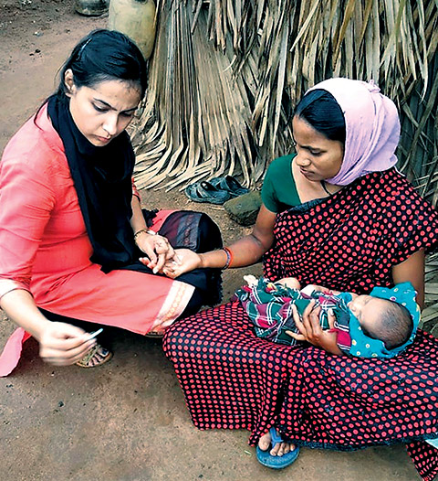 A doctor from the SEARCH team examines a mother and her newborn baby 
