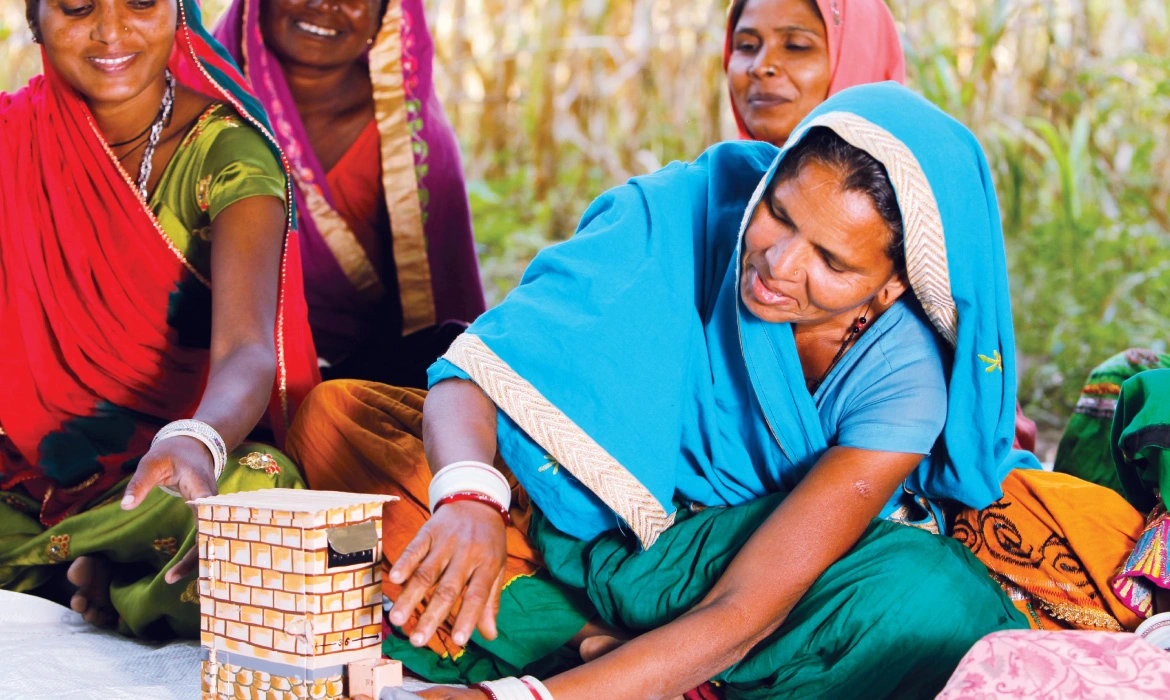 Matu Bai, a member of the water-user group of Bhula village in Sirohi, uses a fabricated model to explain the design of a twin-pit toilet. Mobilising households to construct and use toilets was an important part of the behaviour change campaign