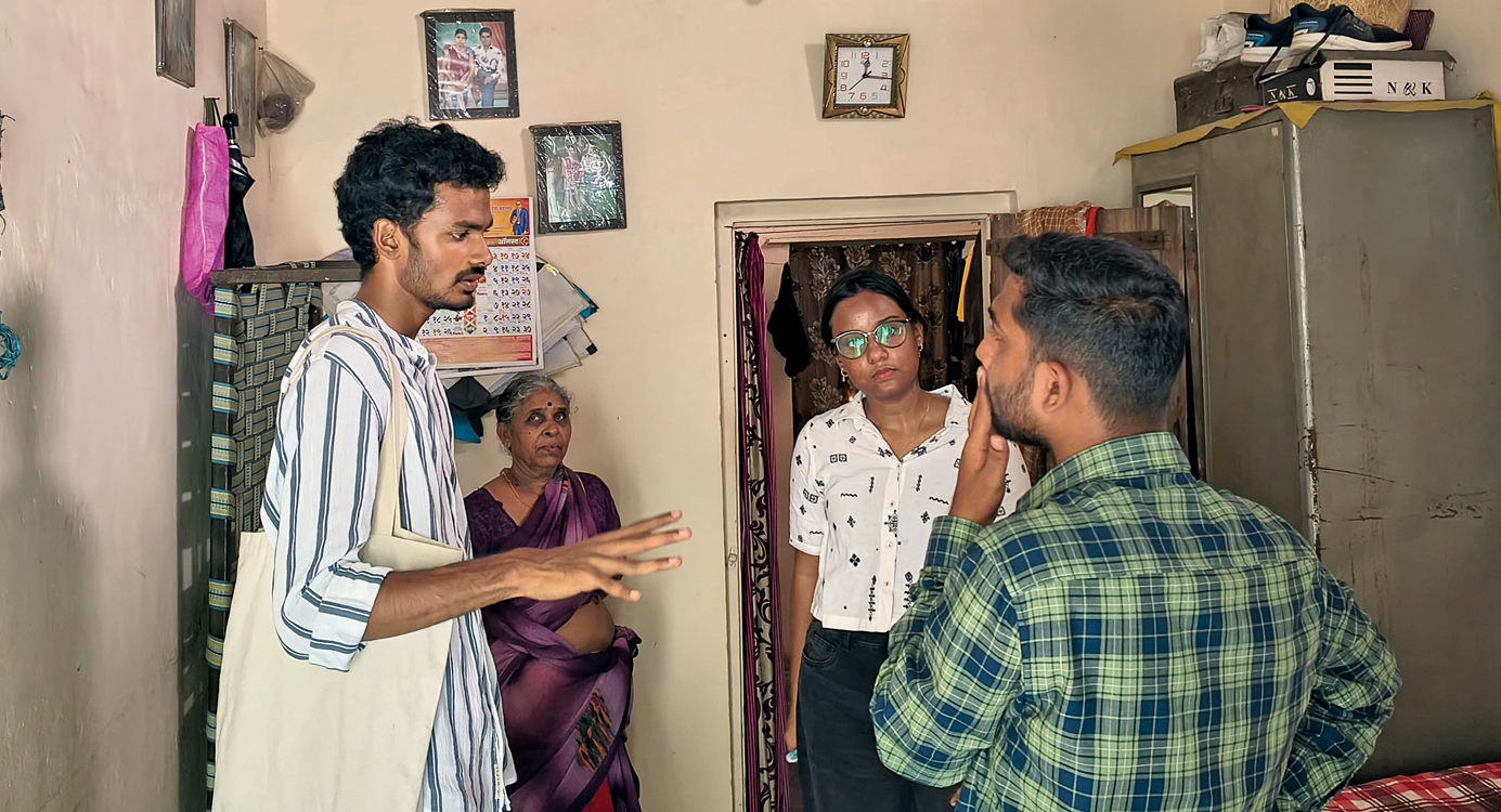 A member of a technical team speaks to residents of a home in Panchasheel Chowk while assessing indoor heat conditions and possible solutions