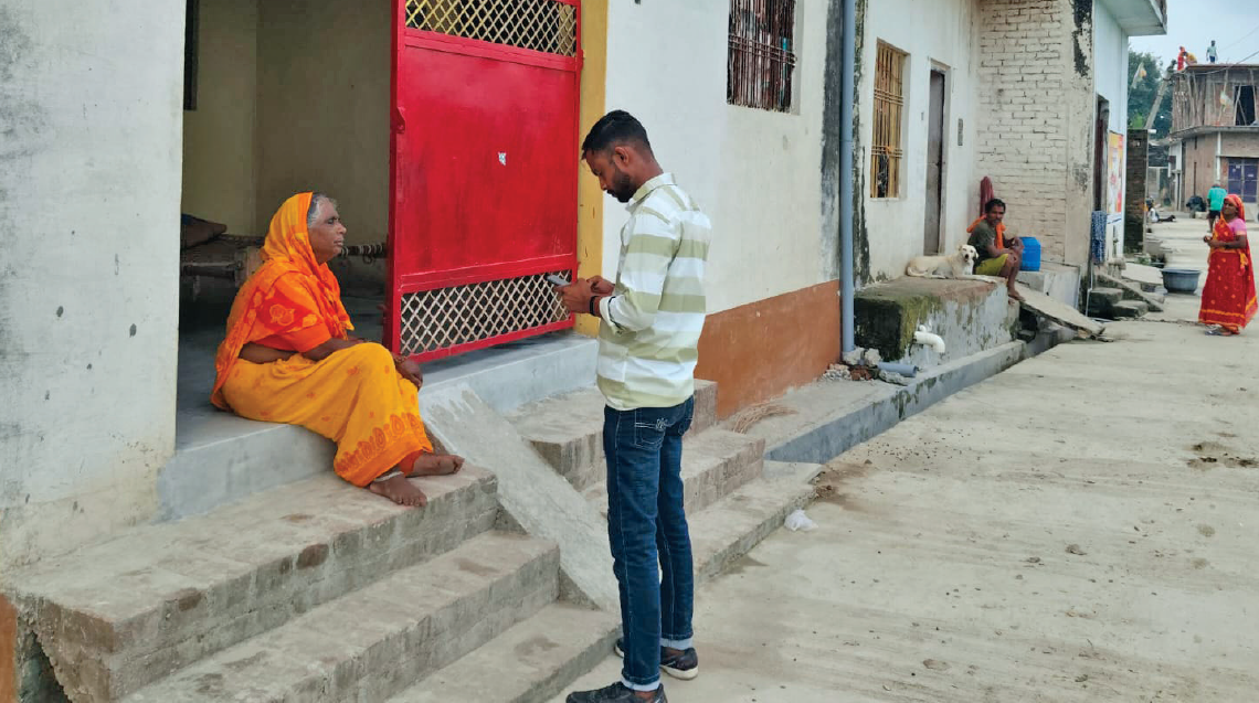 A municipal officer speaks to a resident during a visit to a settlement in Banthra near Lucknow to collect data for the spatial mapping exercise
