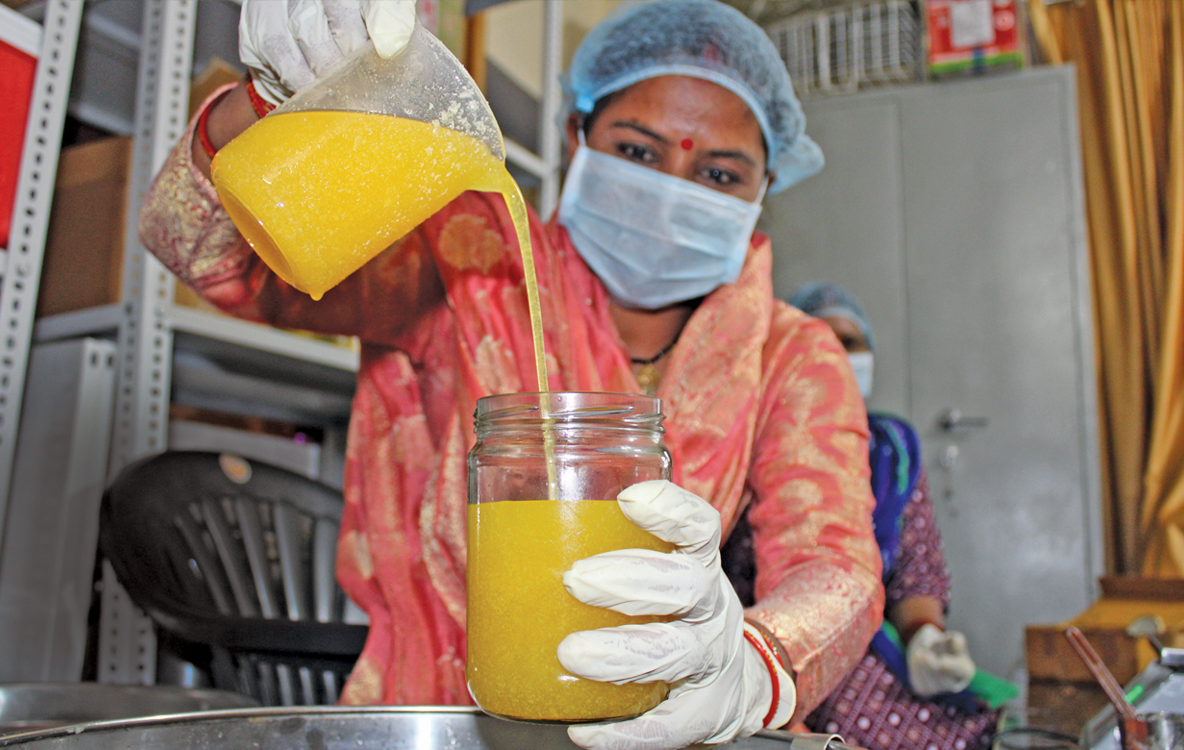 A member of the Kalpganga farmer producer organisation in Paini village near Joshimath packing the A2 ghee for sale